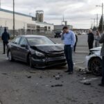 Drivers on their phones after a collision between personal vehicles outside an industrial facility